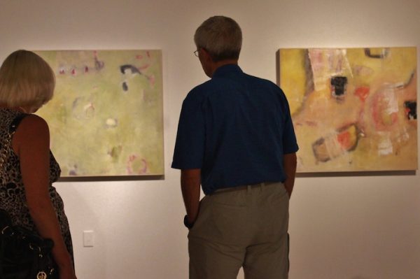 couple admiring contemporary artwork gallery